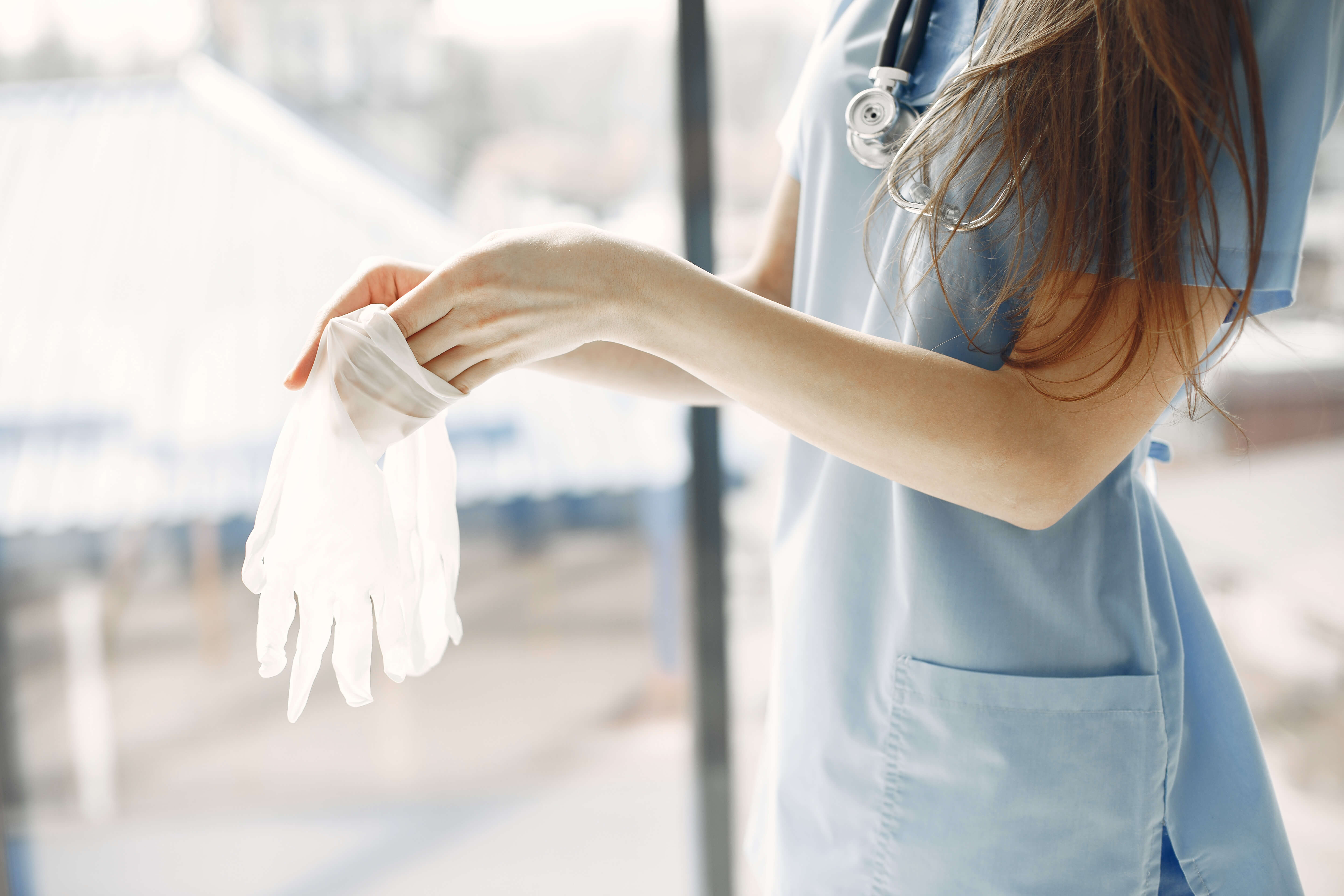 Nurse by the window wearing white gloves