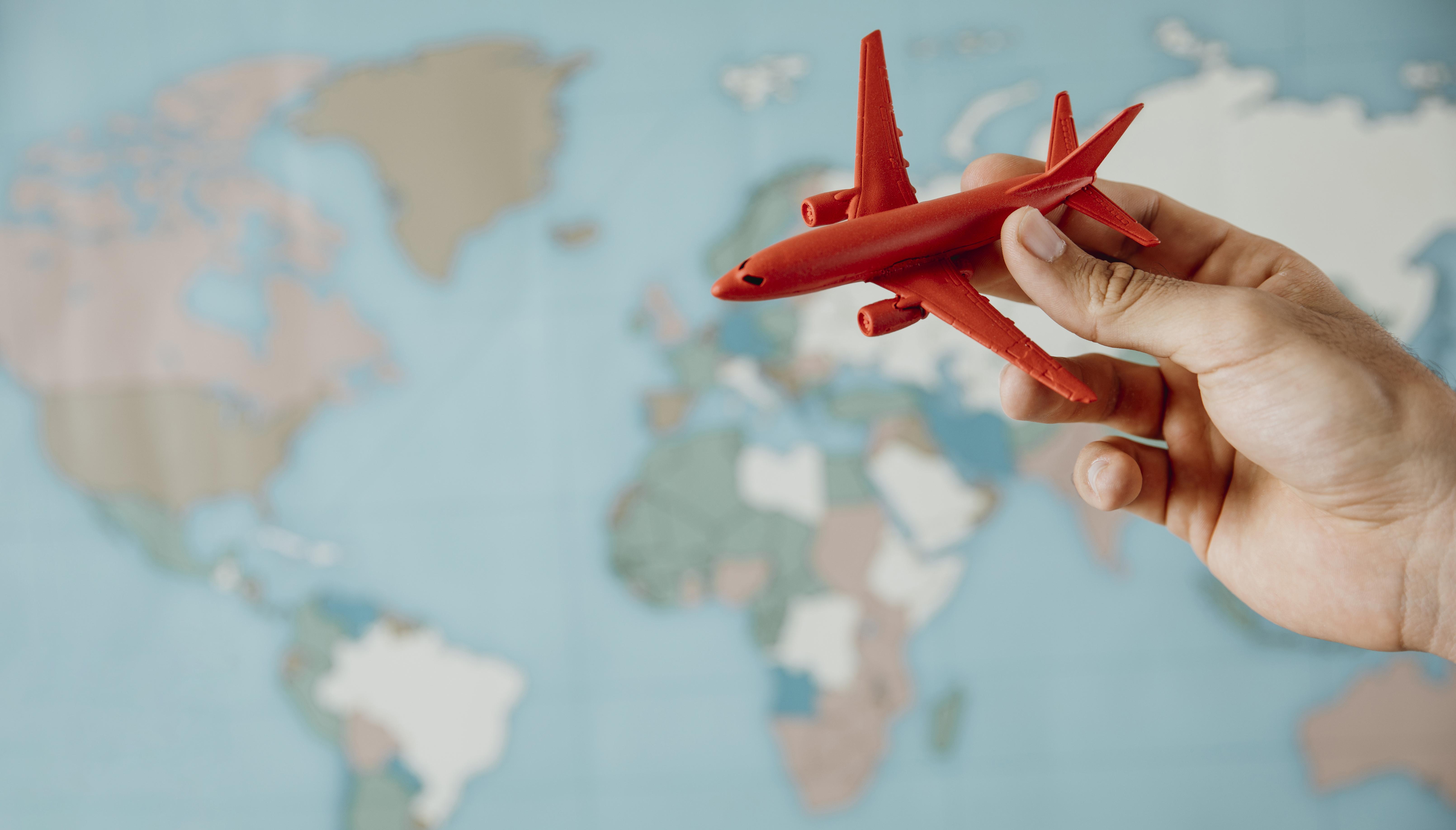 side-view-person-holding-airplane-figurine-map