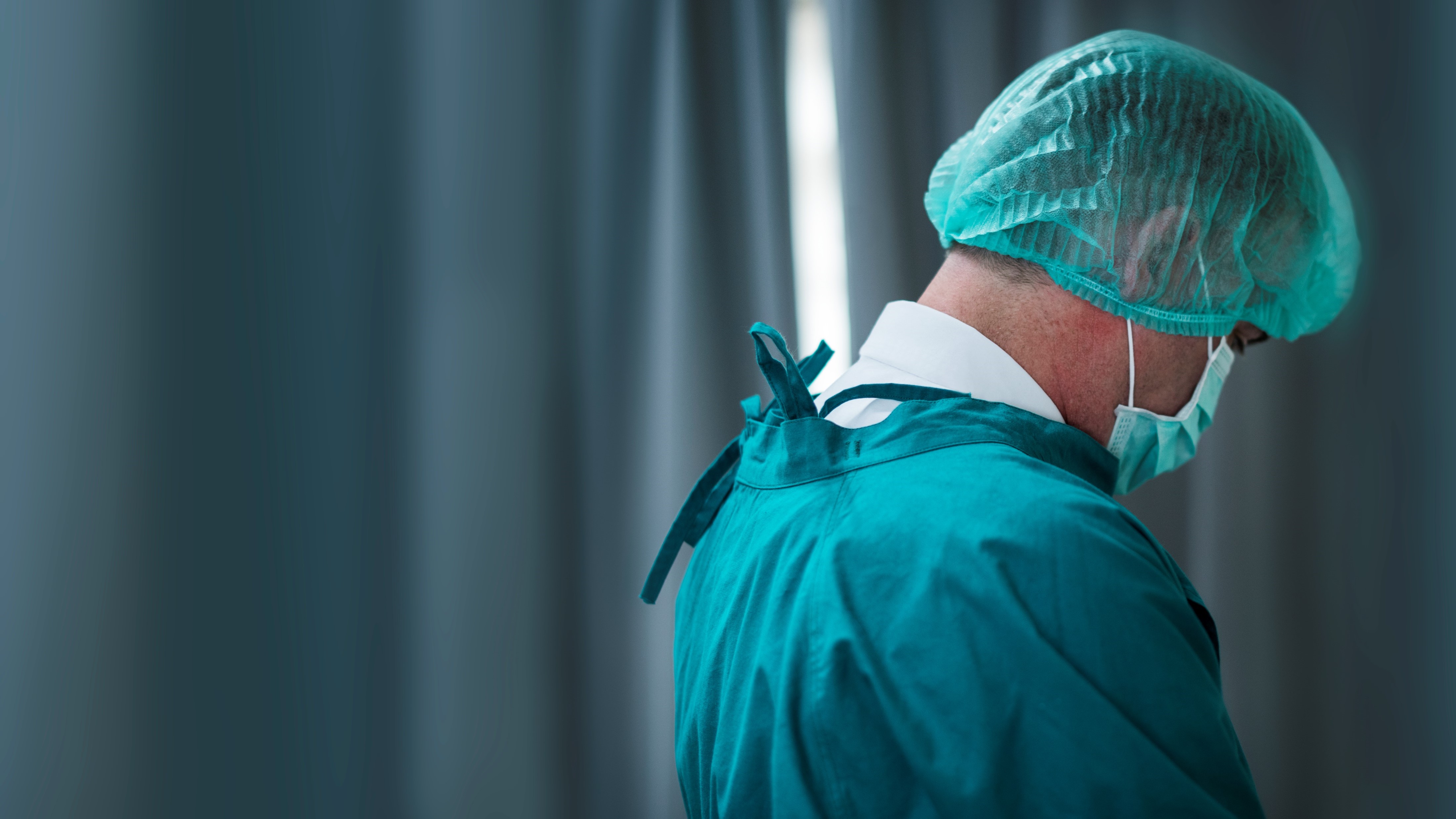 Photo of a nurse facing backwards wearing protective suit