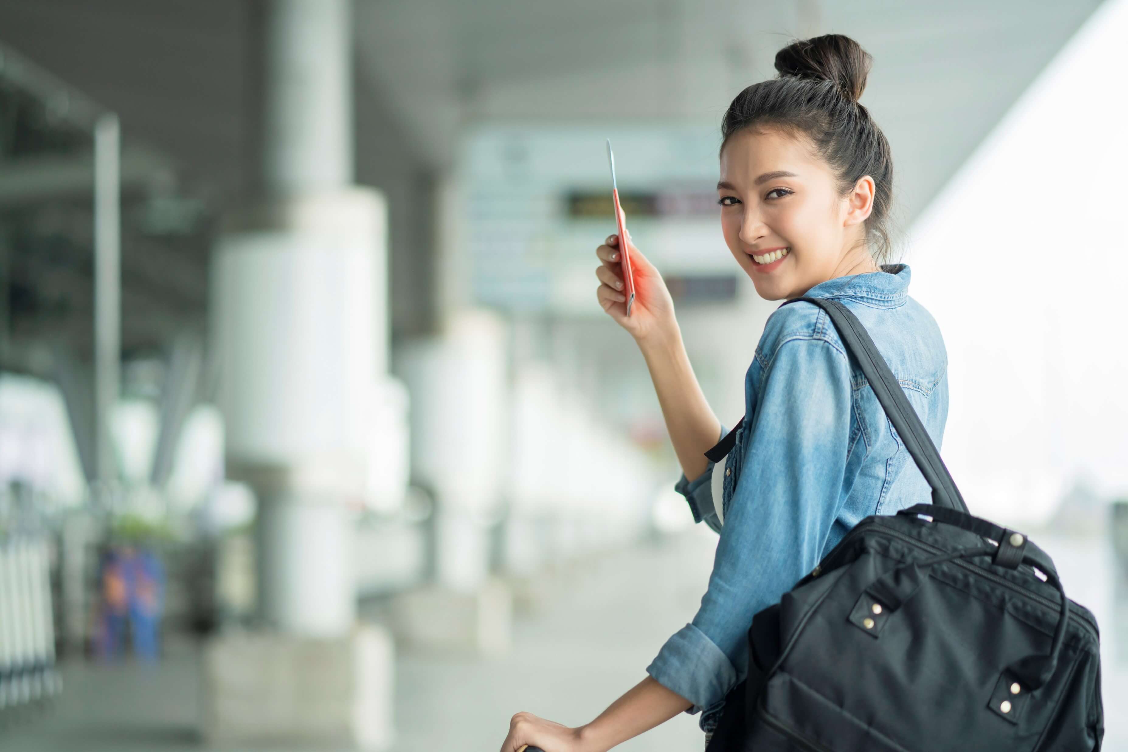 Young woman in the airport holding passport