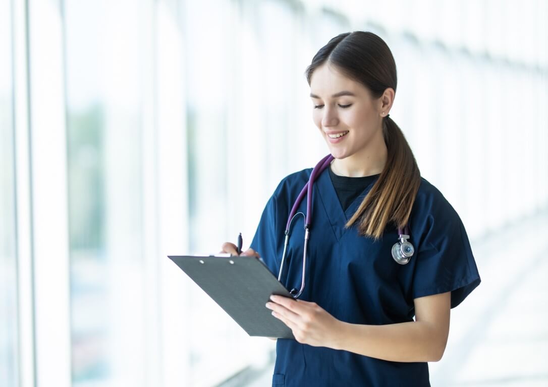 Smiling young female doctor holding a clipboard in hospital