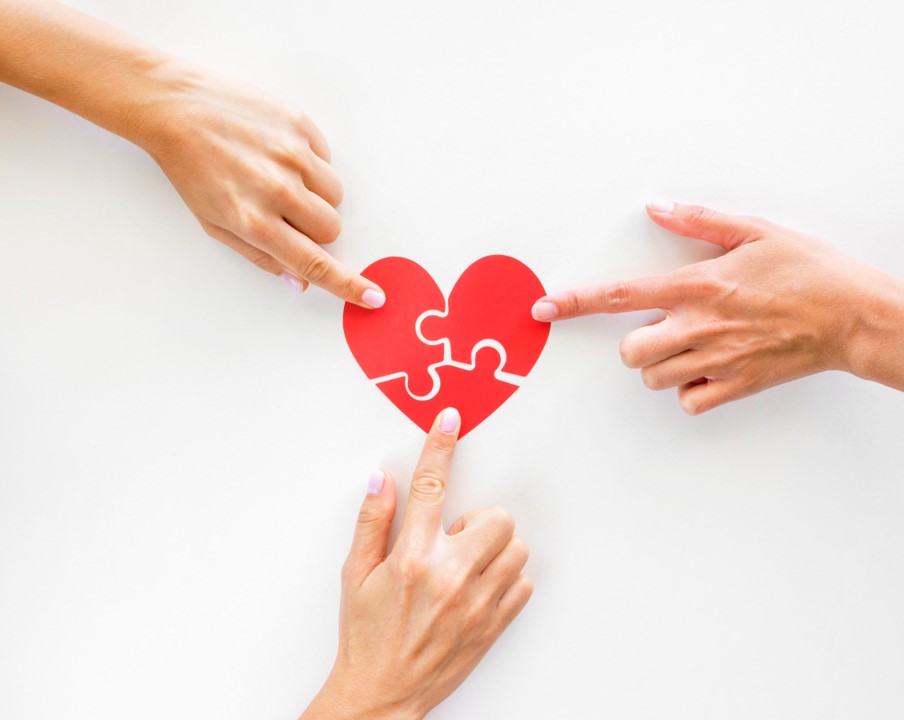 hands touching puzzle heart