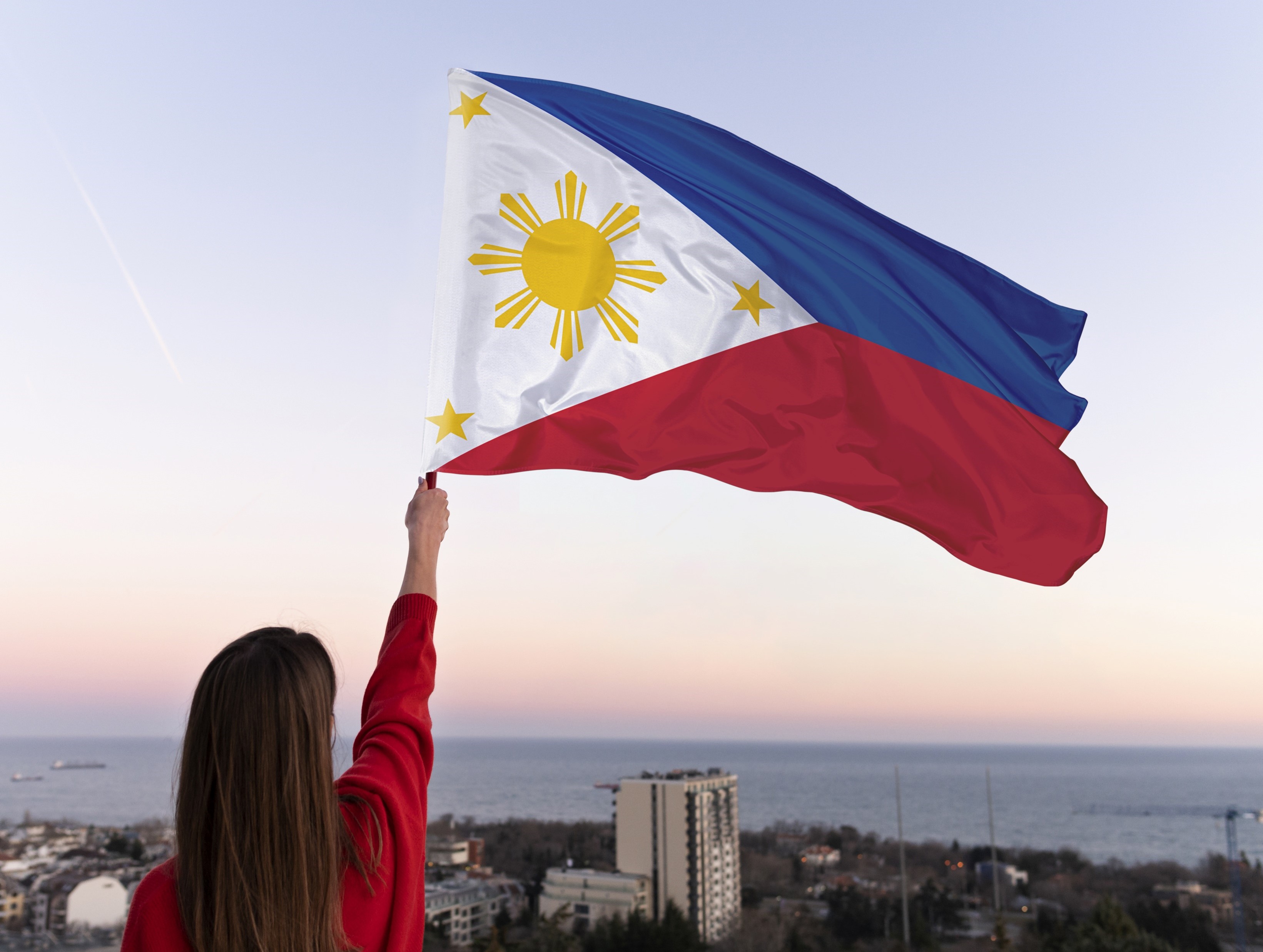 Photo of a woman holding the Philippine Flag